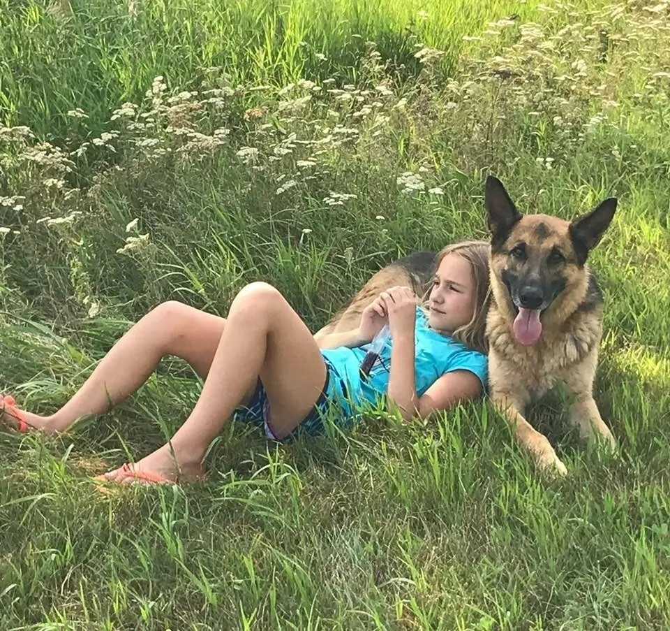A girl is lying on a dog